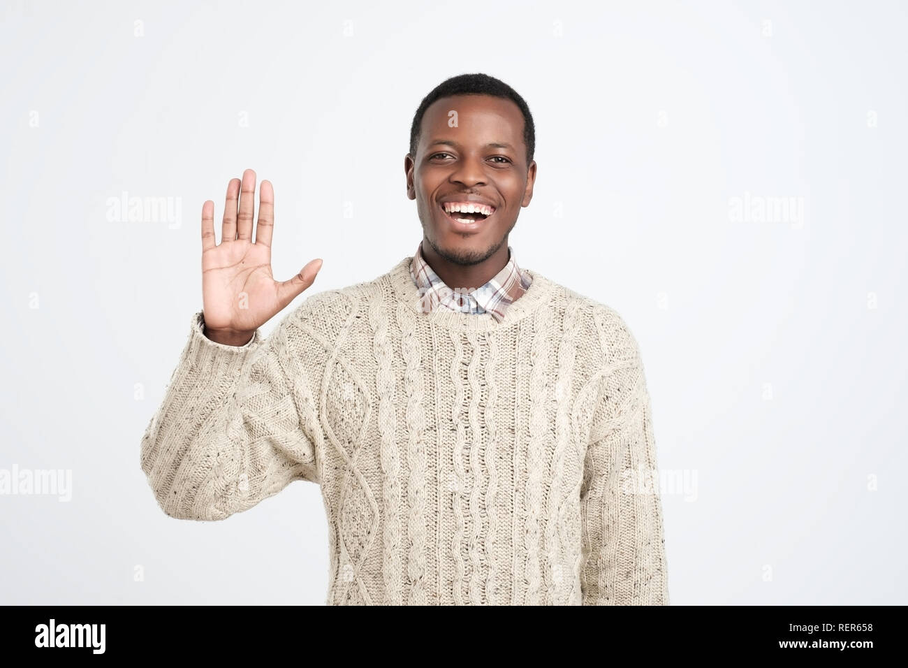 Poli young African American man dressed in sweater dire bonjour Banque D'Images