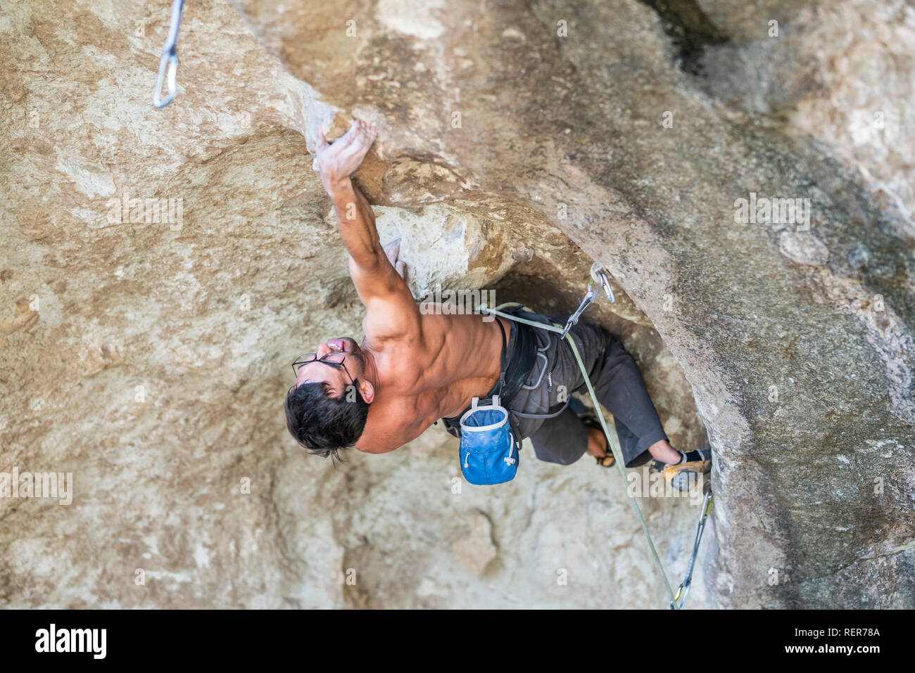 Pratiquer l'escalade sport extrême dans les Andes, au niveau d'une falaise. Un grimpeur mâle fait les mouvements durs avec ténacité et confiance Banque D'Images