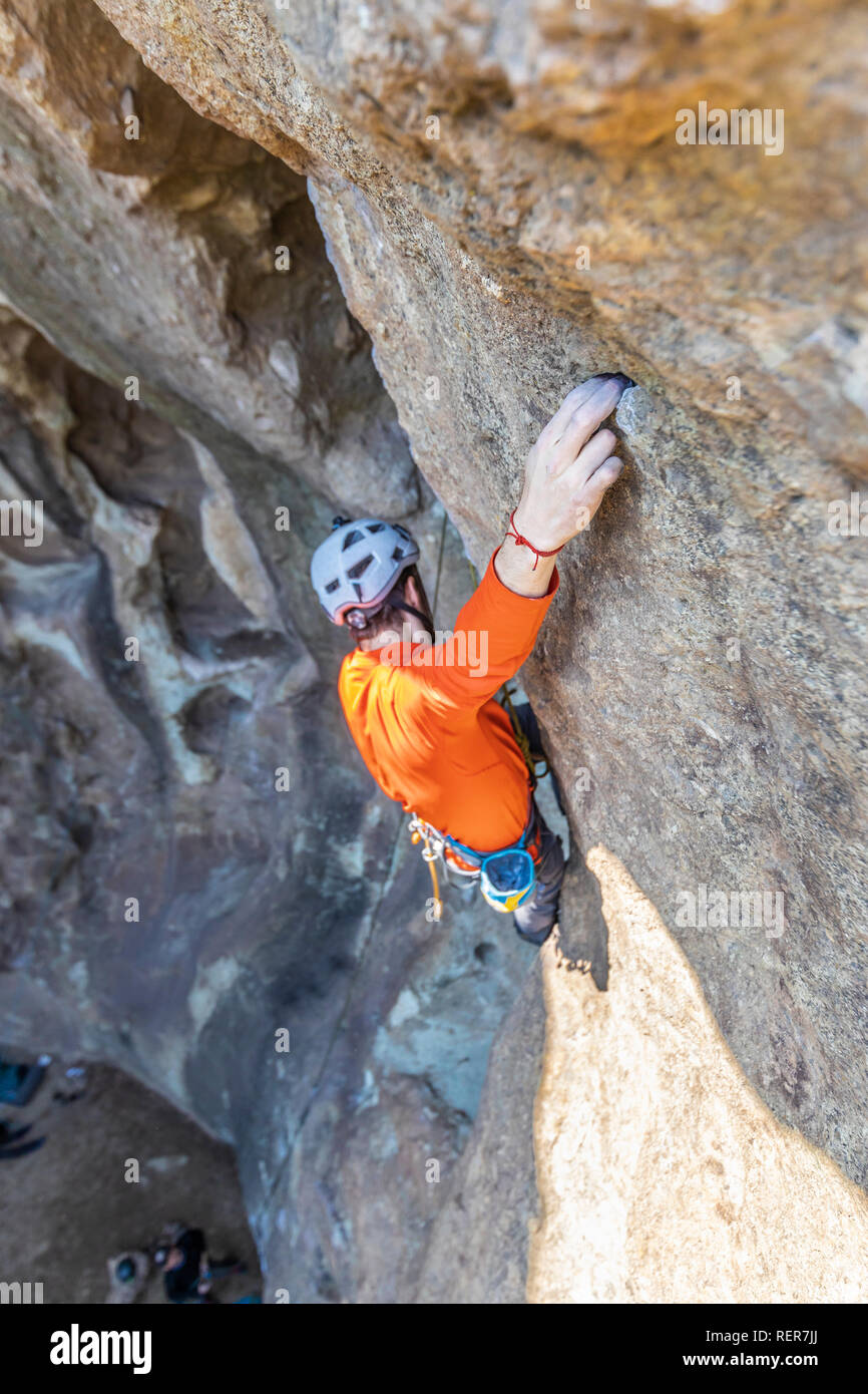 Pratiquer l'escalade sport extrême dans les Andes, au niveau d'une falaise. Un grimpeur mâle fait les mouvements durs avec ténacité et confiance Banque D'Images