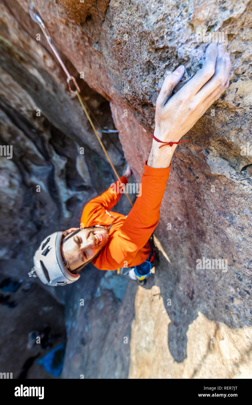 Pratiquer l'escalade sport extrême dans les Andes, au niveau d'une falaise. Un grimpeur mâle fait les mouvements durs avec ténacité et confiance Banque D'Images