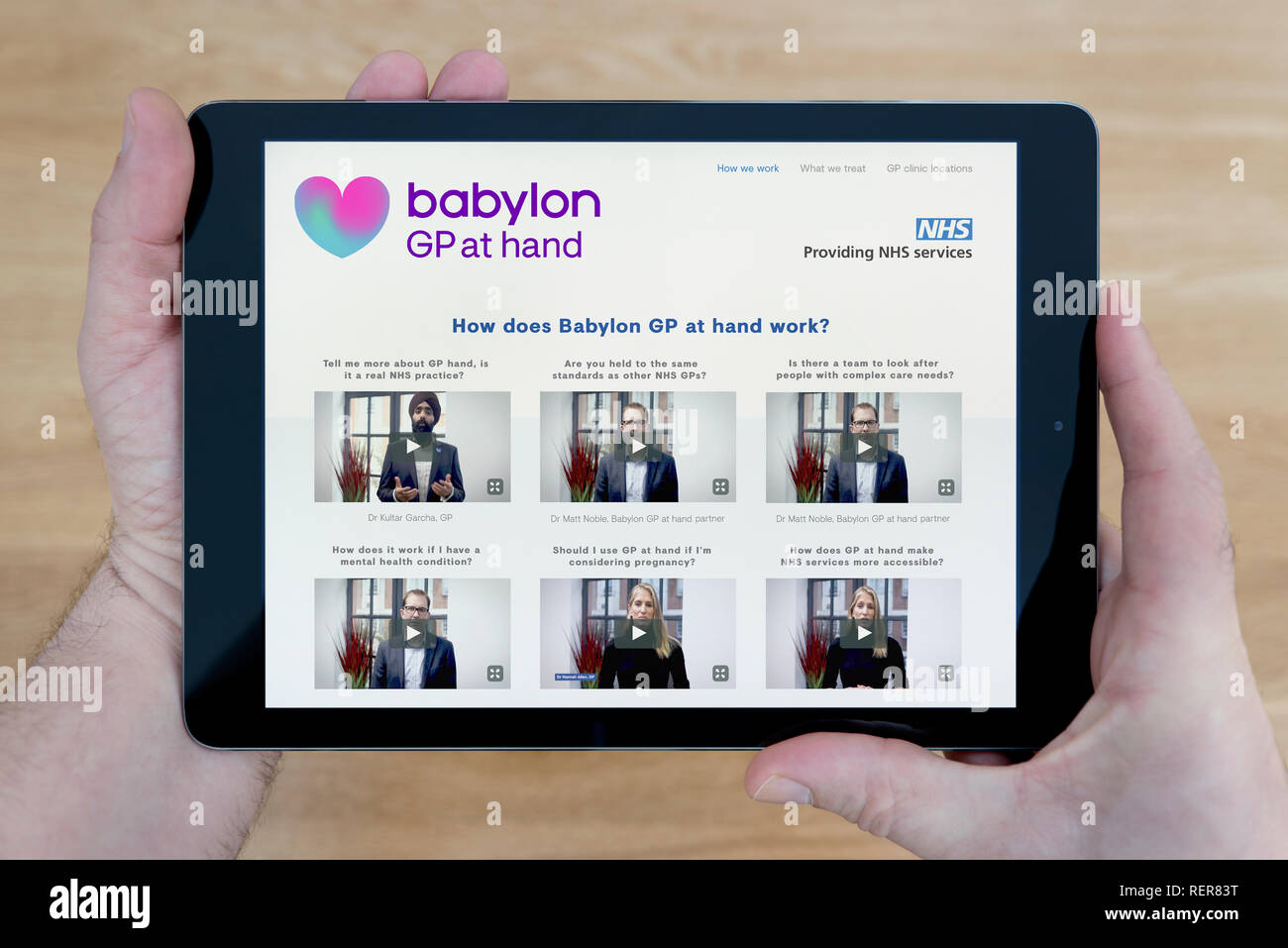 Un homme regarde la Babylone GP à part site sur son iPad tablet device, tourné contre une table en bois page contexte (usage éditorial uniquement) Banque D'Images