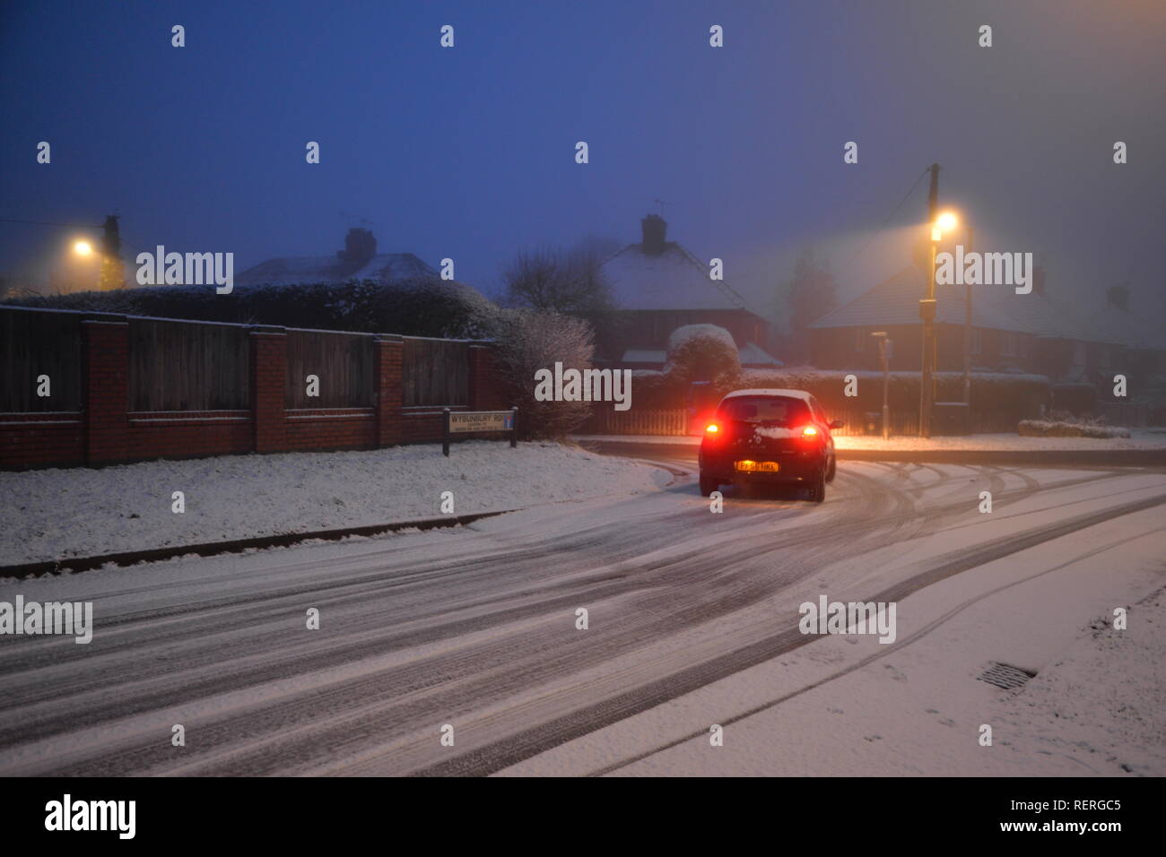 Un tournant de voiture sur une route glacée sur un matin de janvier avec de la neige, la brume et le brouillard dans un hiver au Royaume-Uni. Banque D'Images