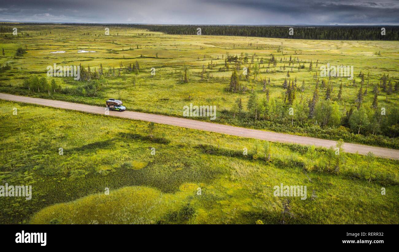 Drone vue, photo aérienne, camping (Ford Ranger avec corps Oman) sur route de gravier dans des milieux humides, marais, forêt boréale de conifères de l'Arctique avec Banque D'Images
