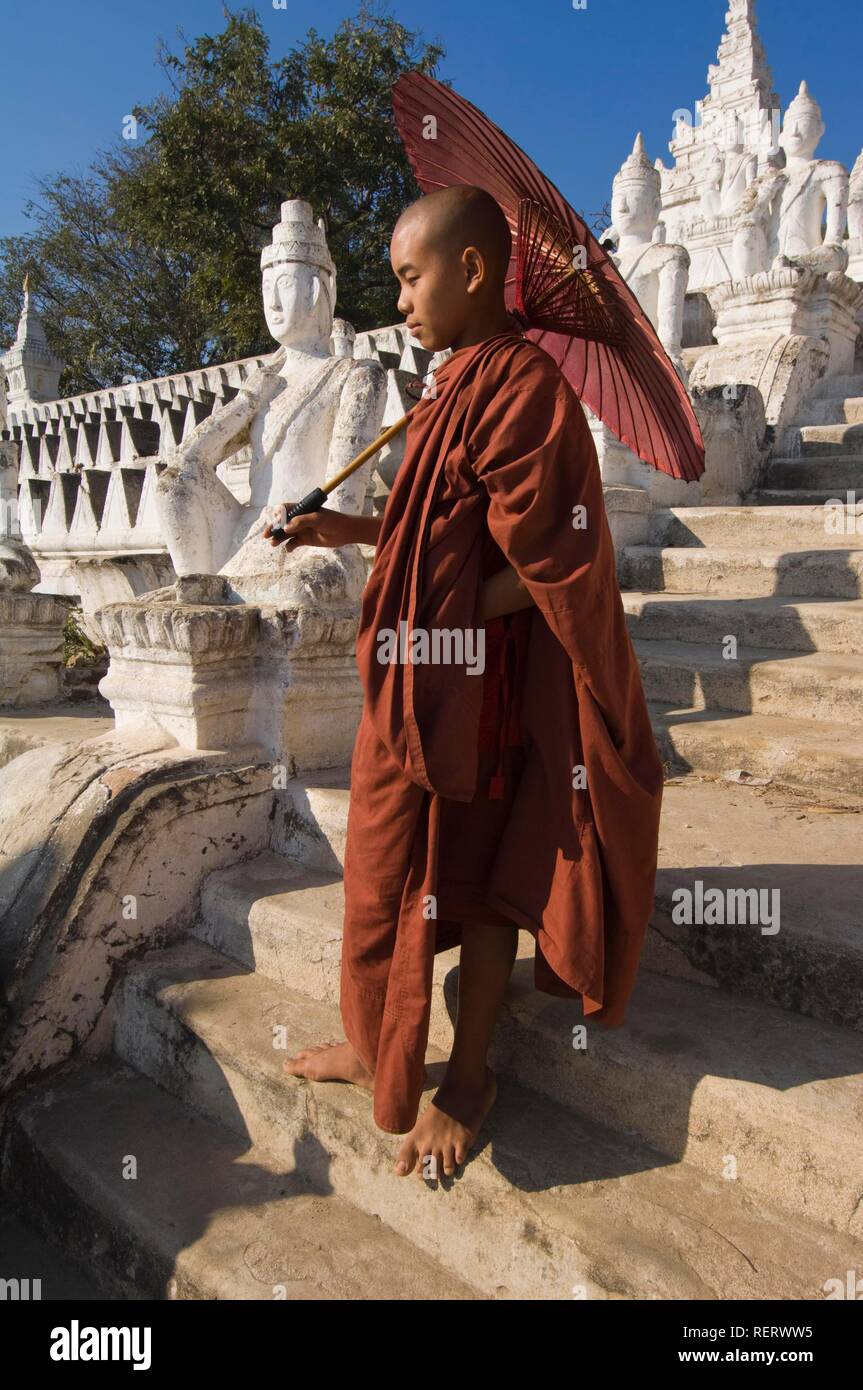 Jeune moine bouddhiste avec un parapluie rouge, Settawya, Pagode Mingun, Birmanie, Myanmar, en Asie du sud-est Banque D'Images