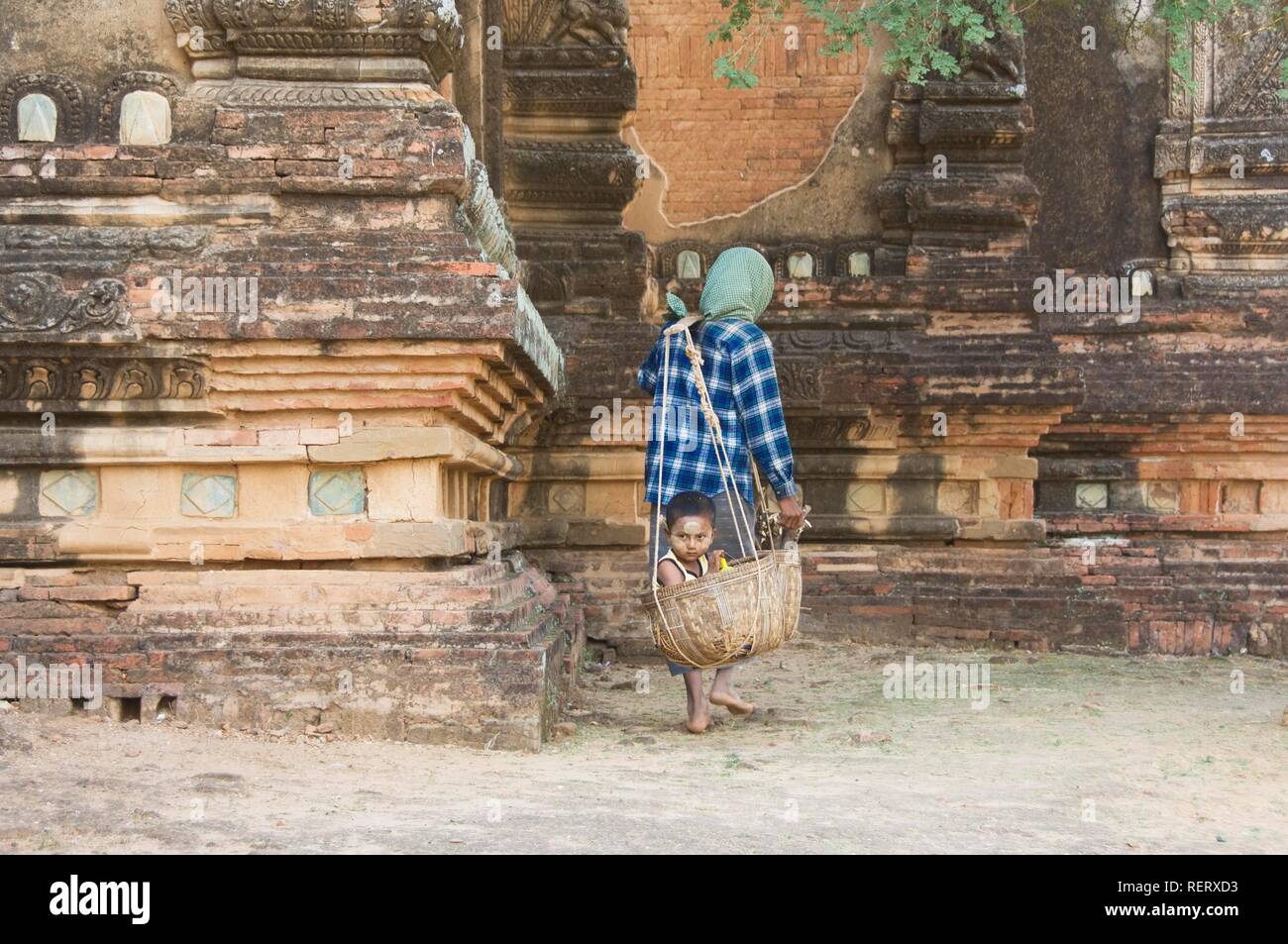 Femme birmane portant son garçon dans un panier, Bagan, Myanmar, Birmanie Banque D'Images
