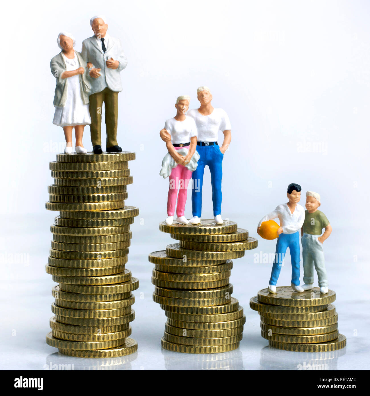 Photo symbole, finances, famille, figurines assis sur pile de pièces Banque D'Images