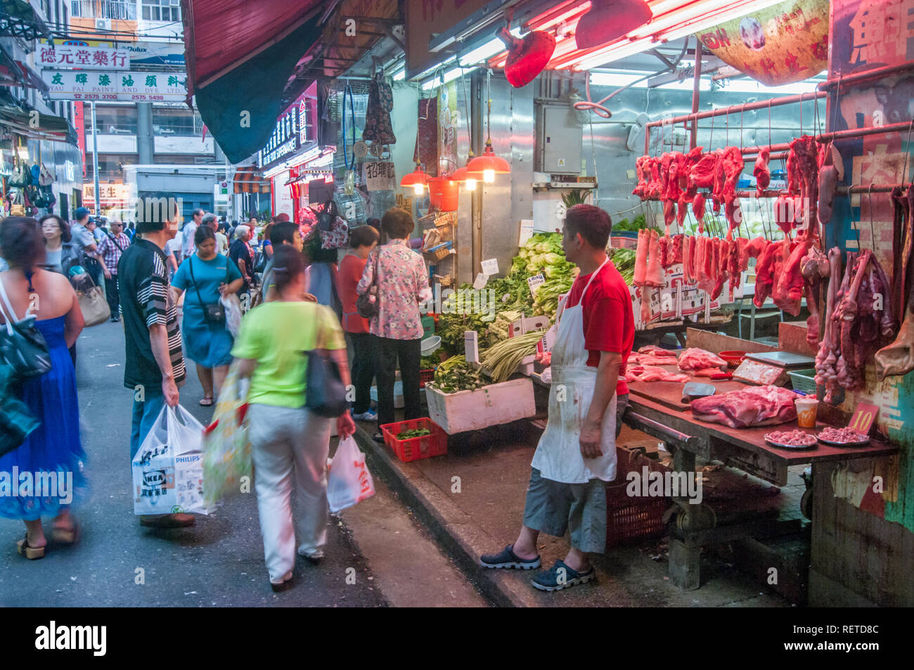 Les gens magasinent pour une variété de biens et services dans des marchés en plein air avec des couleurs vibrantes à Hong Kong, Chine Banque D'Images