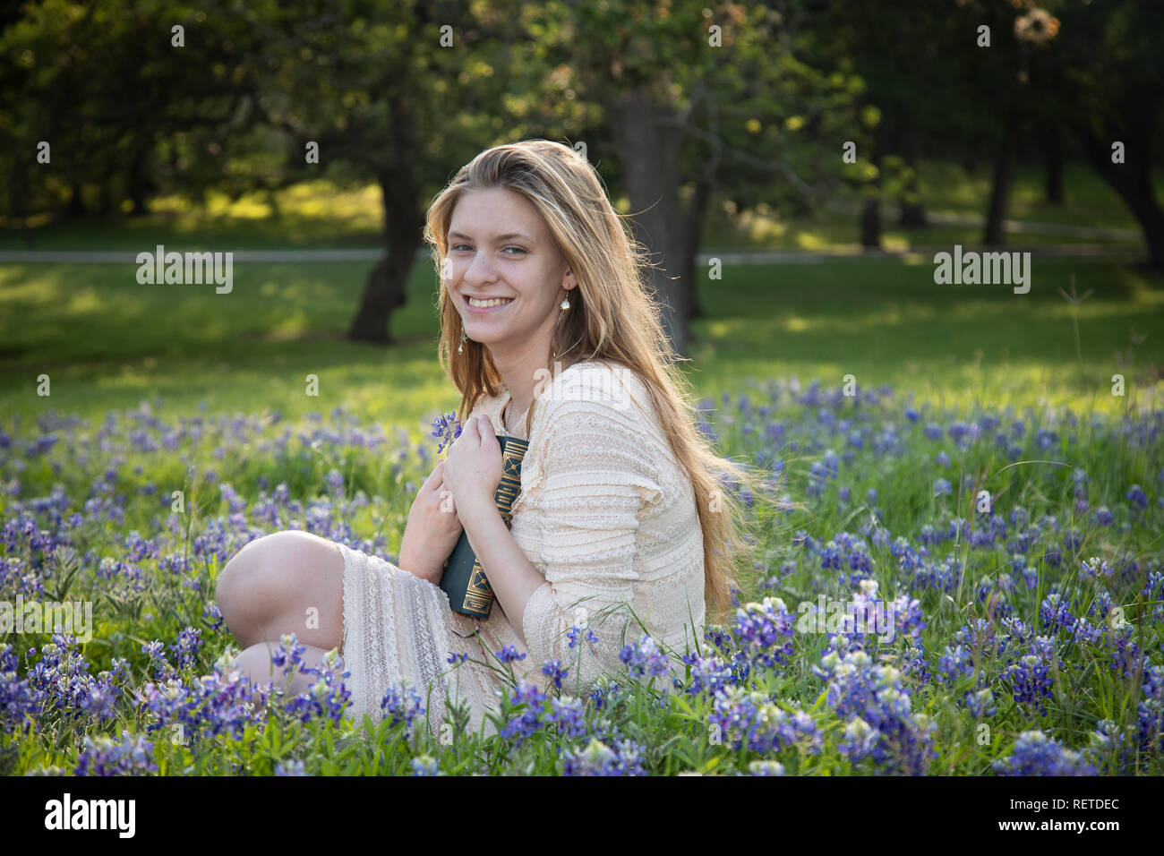 Girl Reading a book in fleurs bluebonnet Banque D'Images