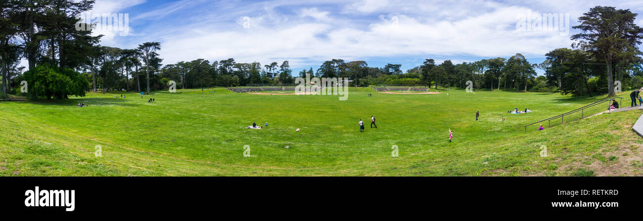 6 mai 2018 San Francisco / CA / USA - personnes bénéficiant d'une belle journée sur l'une des vertes prairies dans le Golden Gate Park, terrains de baseball dans le background Banque D'Images