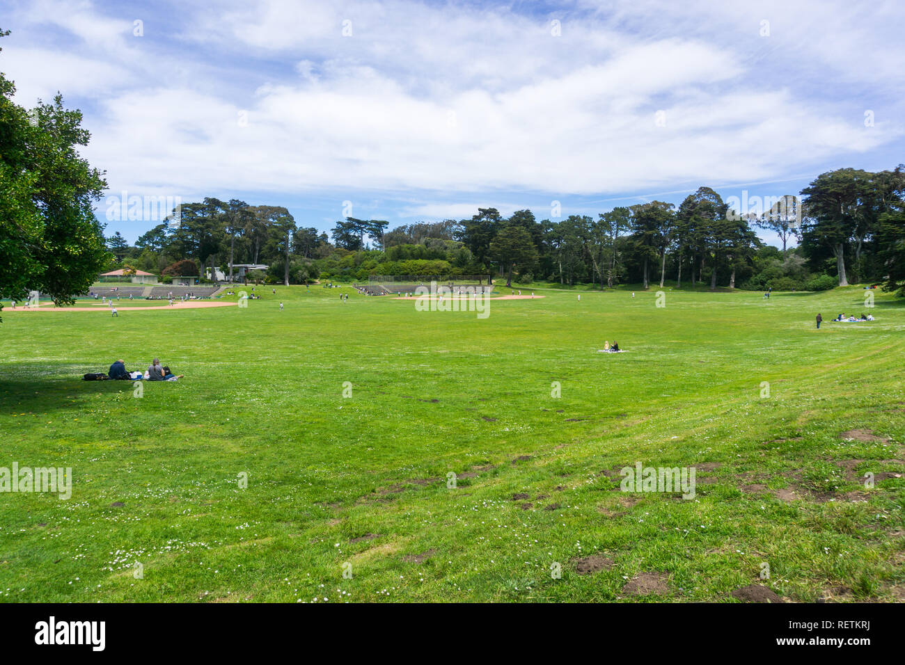 6 mai 2018 San Francisco / CA / USA - personnes bénéficiant d'une belle journée sur l'une des vertes prairies dans le Golden Gate Park, terrains de baseball dans le background Banque D'Images