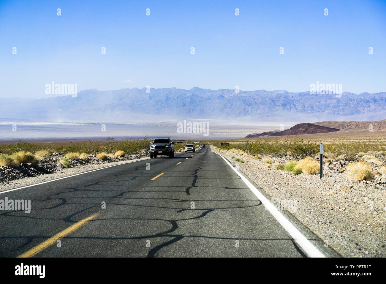 La conduite sur une longue ligne droite, l'autoroute à travers la Death Valley National Park, California Banque D'Images