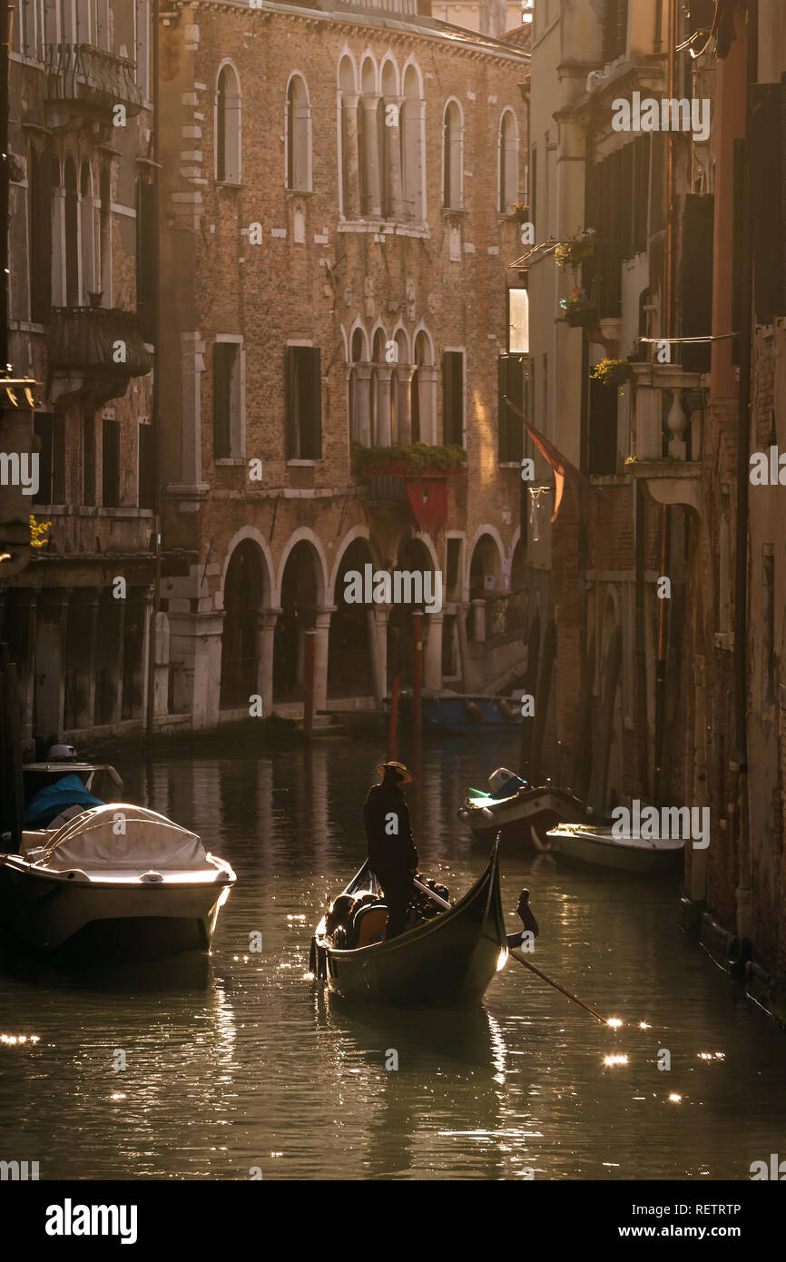 Gondolier vénitien équitation les touristes en gondole à canal latéral à Venise, Italie Banque D'Images