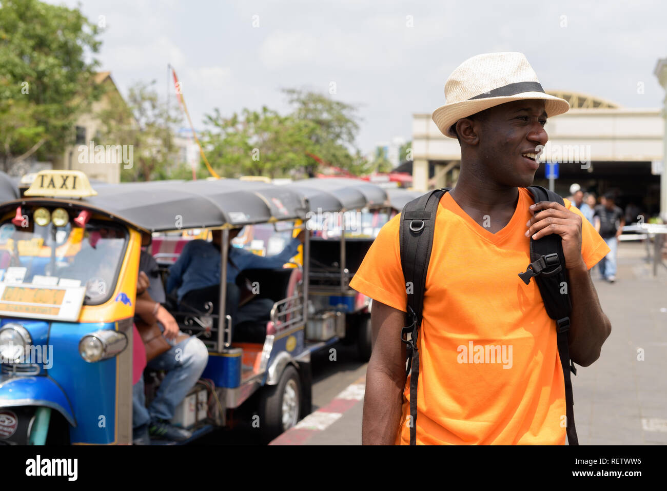 Happy black African'homme à Bangkok avec des taxis tuk tuk Banque D'Images