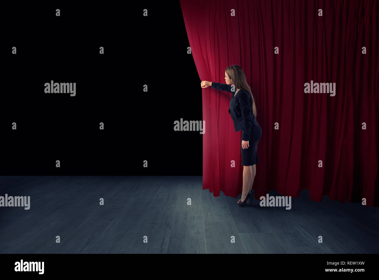 Femme ouvrir des rideaux rouges de la scène de théâtre Banque D'Images