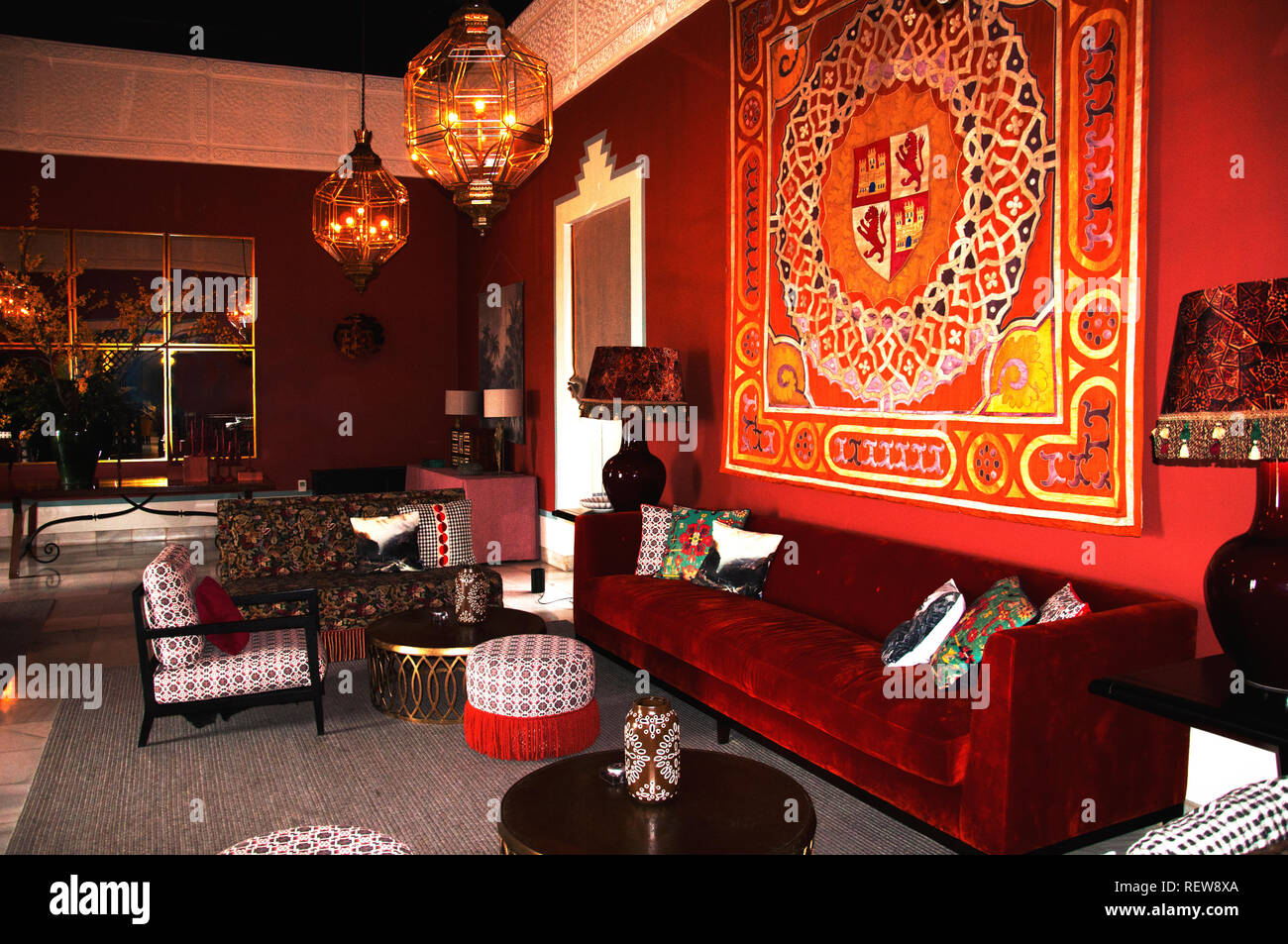 Ancien de l'Intérieur espagnol classique avec grand canapé en velours rouge, des chaises et des tapis sur le mur Banque D'Images