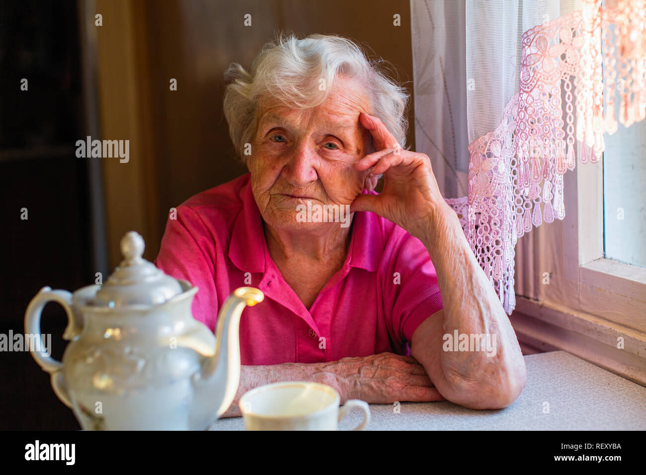 Portrait d'une femme âgée dans sa maison à la cuisine. Banque D'Images