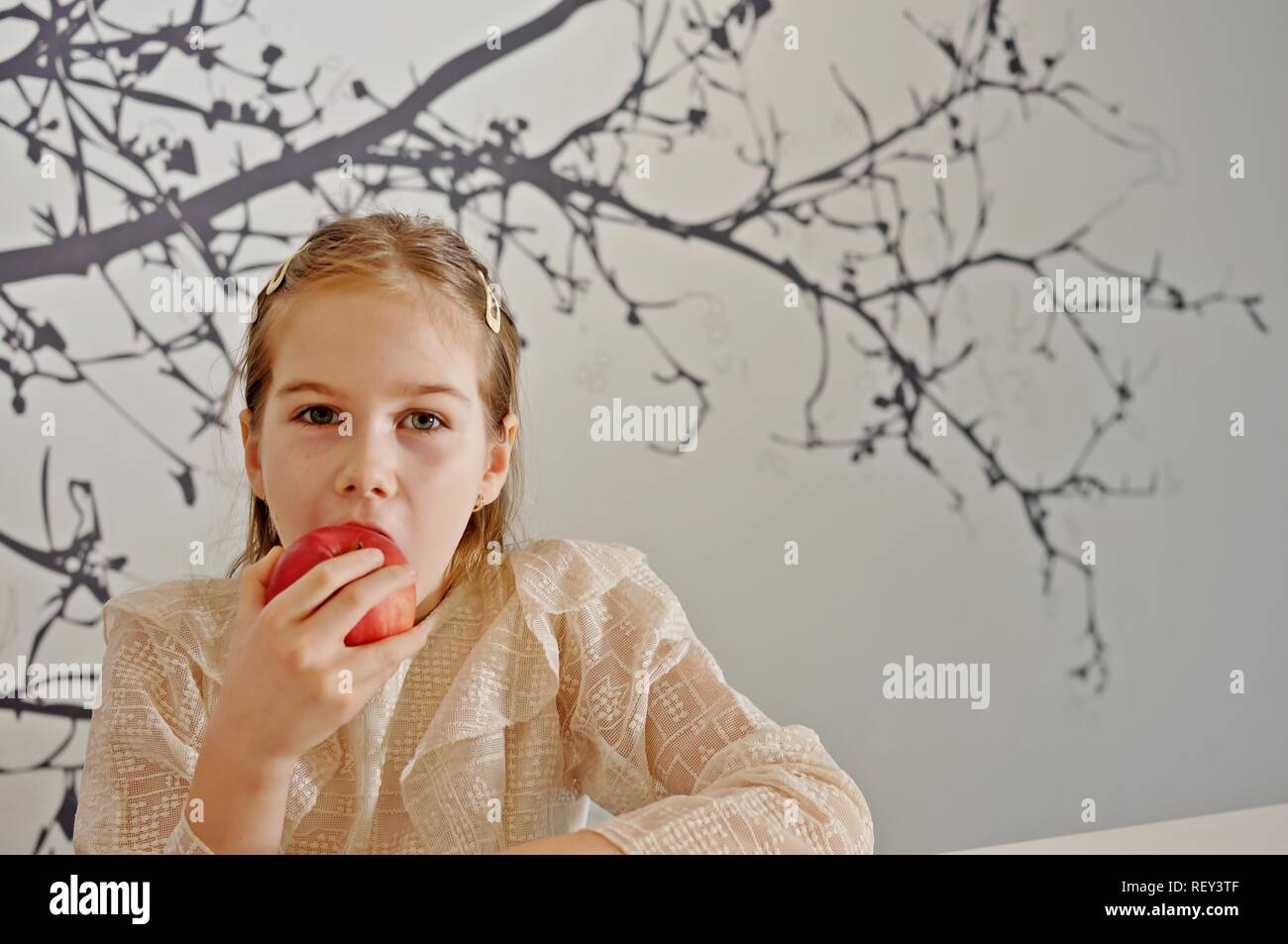 White Caucasian girl (enfant, kid) manger une pomme rouge. Copier du texte Banque D'Images