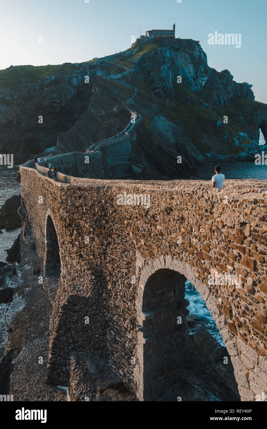 L'homme regardant San Juan de Gaztelugatxe's Chapel au coucher du soleil, Pays Basque Banque D'Images