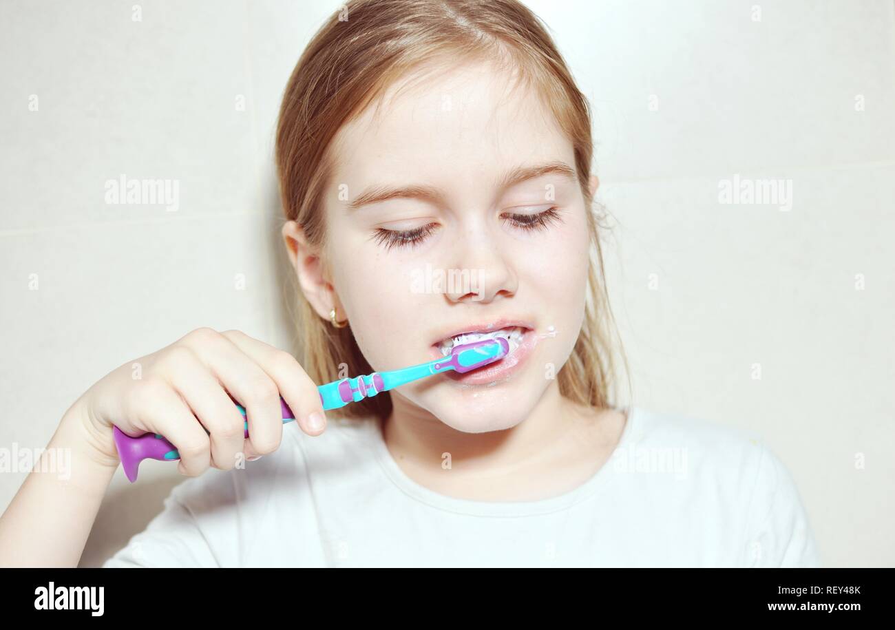 Portrait d'un enfant (Kid) white Caucasian girl européenne lave les dents avec une brosse à dents Banque D'Images