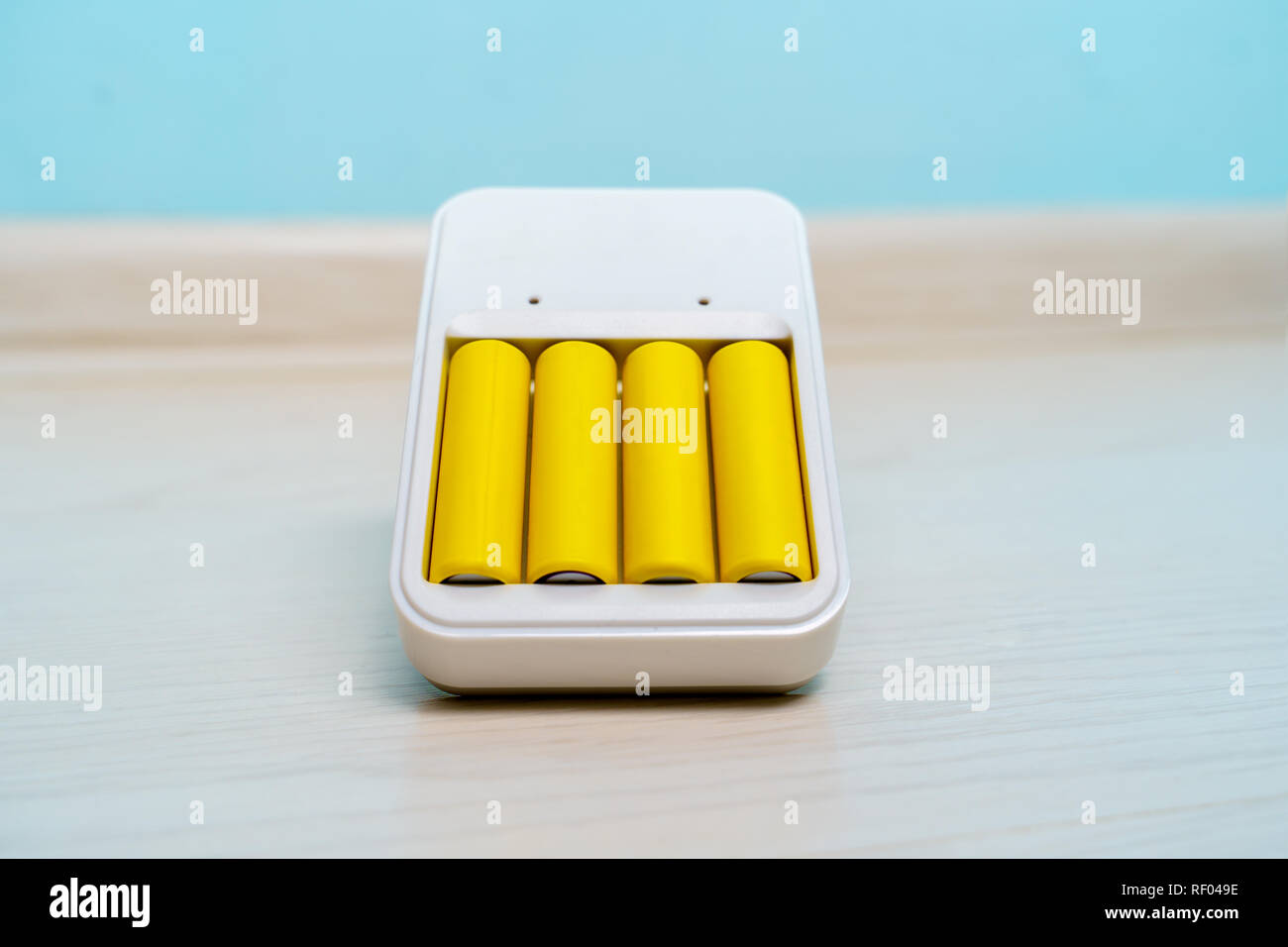 Photo de chargeur avec deux batteries vides sur fond bleu Banque D'Images