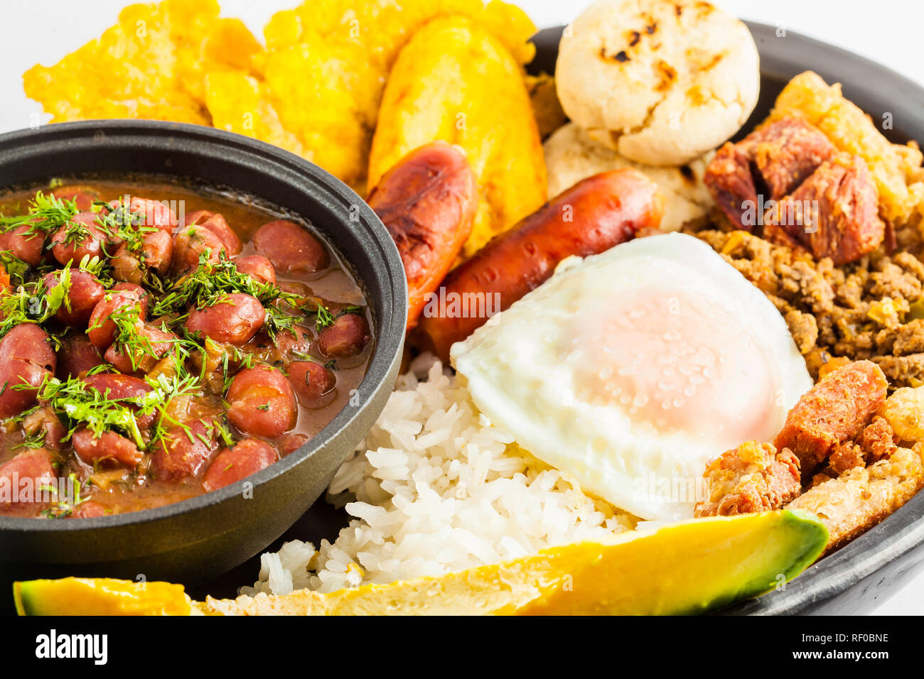 Plat colombien traditionnel appelé Bandeja Paisa: Un plat typique de Medellin qui comprend de la viande, des haricots, des oeufs et des plantain Banque D'Images