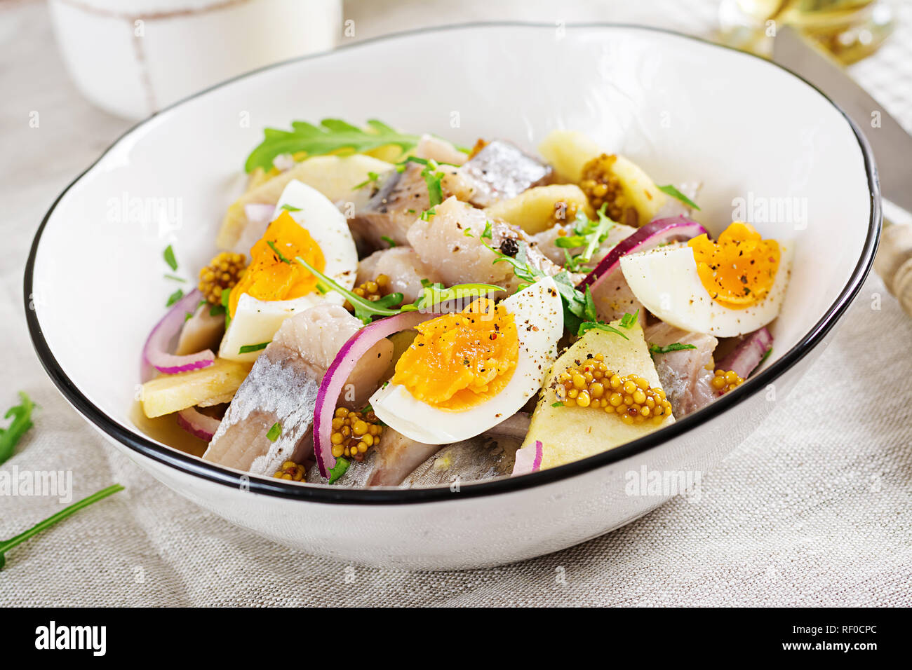 Salade traditionnelle de hareng salé, filet mignon, pommes fraîches, oignon rouge et d'œufs. Ces aliments. La cuisine scandinave. Banque D'Images