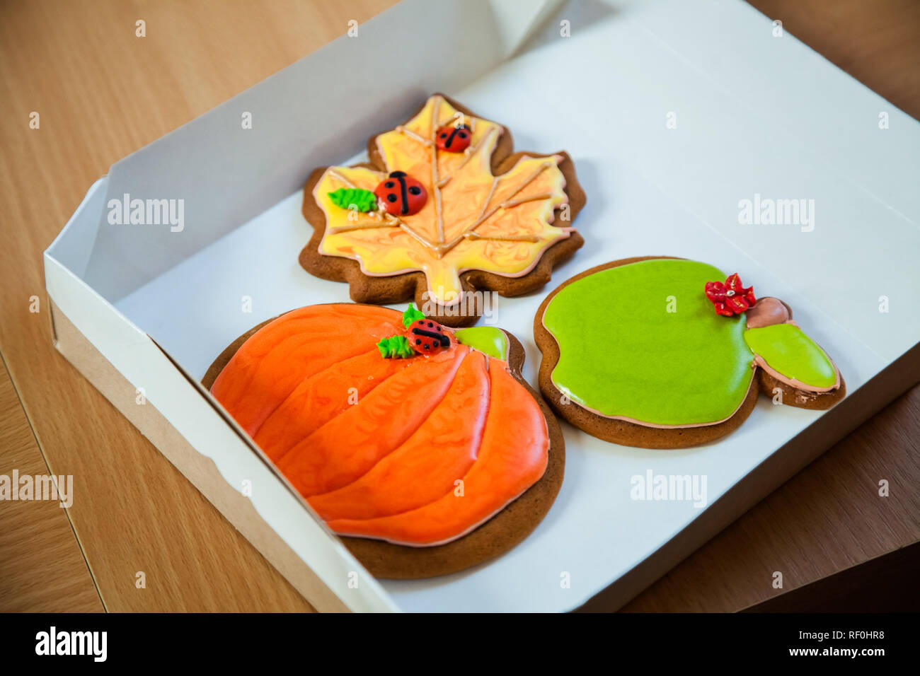 Gingerbread cookies faits maison en forme de citrouilles pour l'Halloween. Automne feuilles d'érable sur le vieux fond de bois. Banque D'Images
