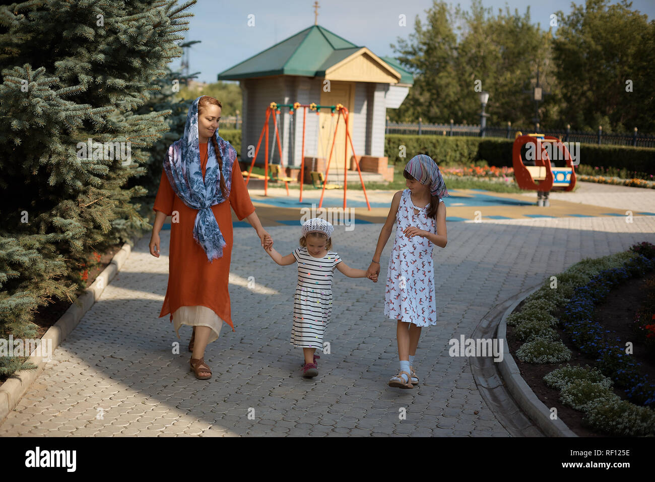 Femme Russe orthodoxe dans une écharpe va de pair avec ses filles, la fête  des mères Photo Stock - Alamy