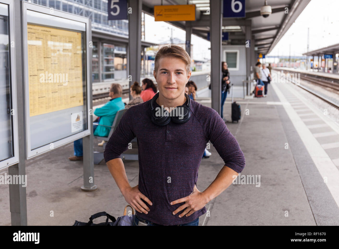 Jeune homme avec les mains sur les hanches, debout à la gare ferroviaire à Aschaffenburg, Allemagne Banque D'Images