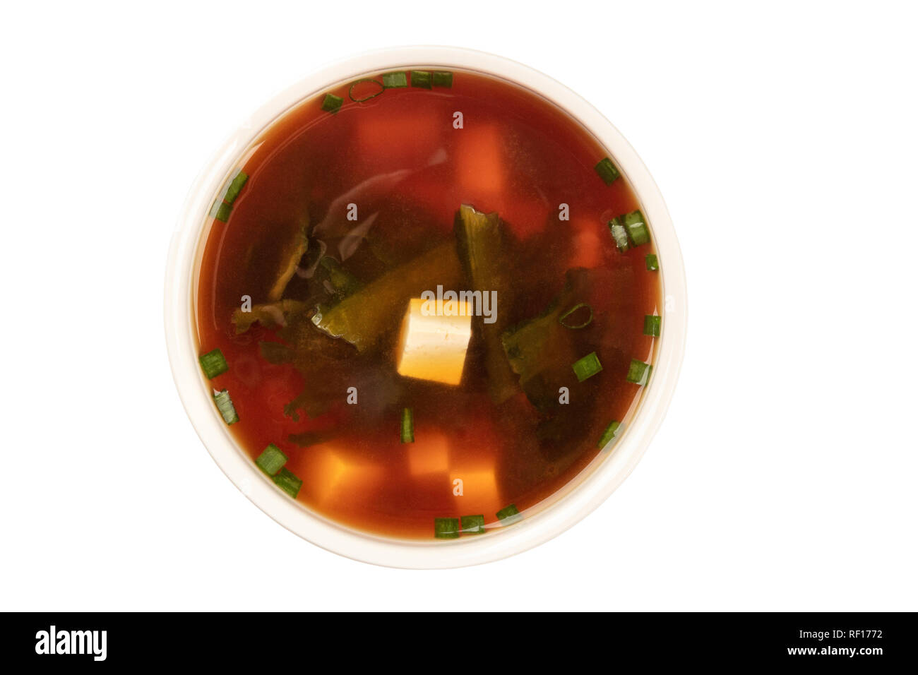 Une photo d'un bol de soupe miso avec le tofu, les échalotes, et les algues wakame, tiré par le haut, isolé sur un fond blanc avec un chemin de détourage Banque D'Images