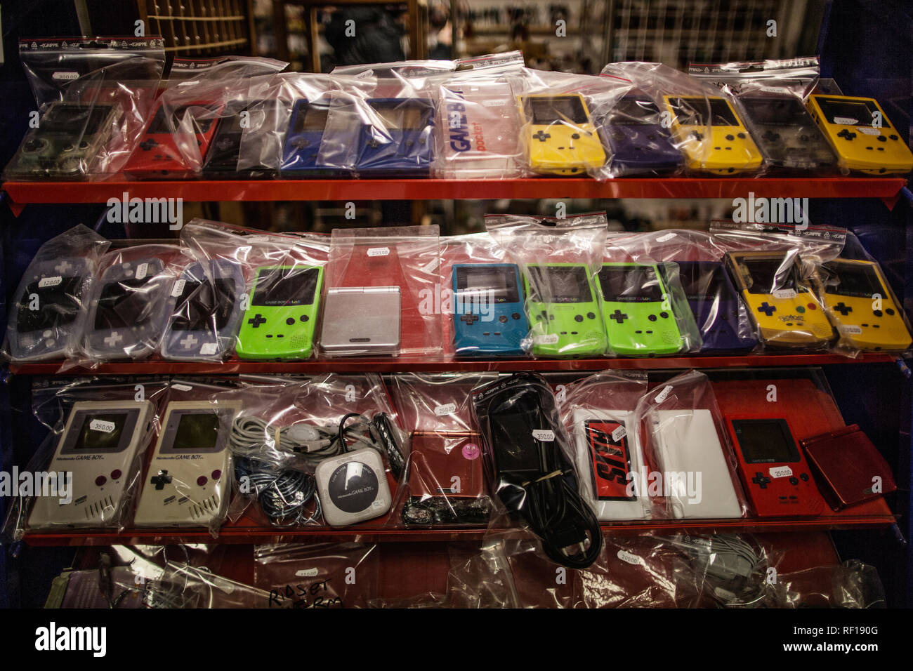 Différentes couleurs et modèles de Game Boy's sur une étagère. Banque D'Images Différentes couleurs et modèles de Game Boy's sur une étagère. Banque D'Images