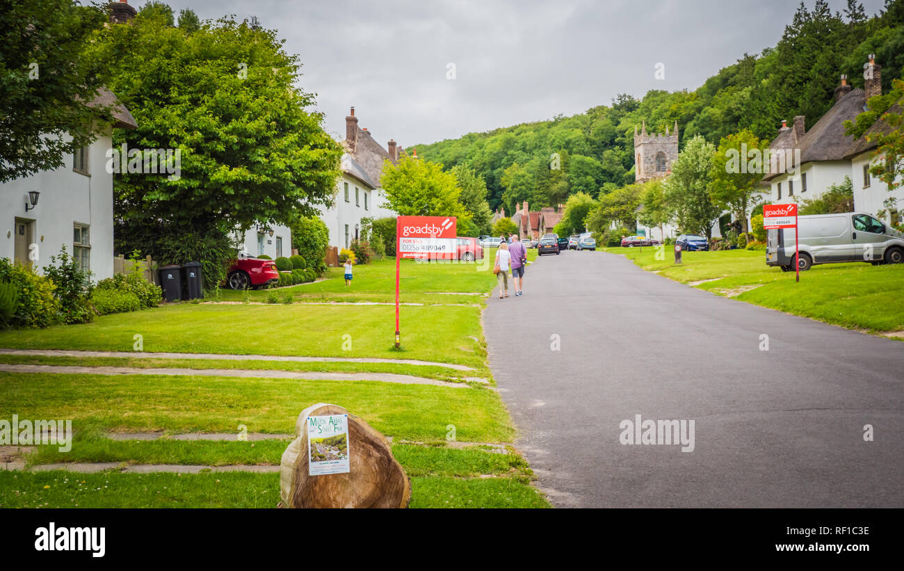 Milton Abbas, Dorset / UK - 0711 2017 : Ancien village médiéval français dans le sud-ouest du Royaume-Uni. Rue avec maisons ancienne chaumière en Angleterre. Banque D'Images