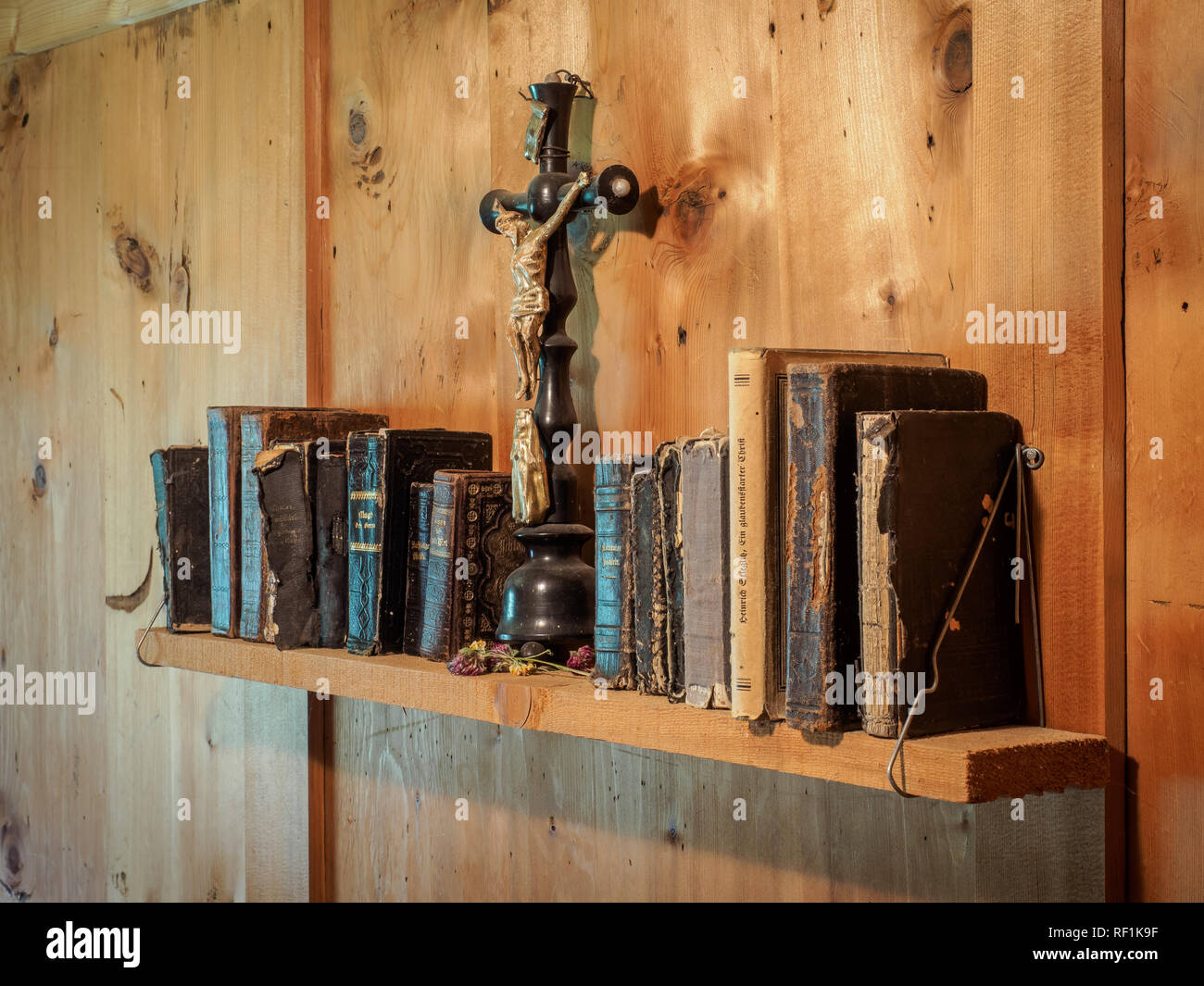 Ancien crucifix et livres religieux anciens sur une étagère dans un vieux  chalet de montagne Photo Stock - Alamy