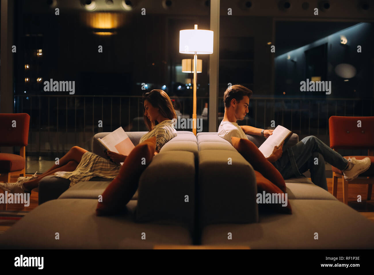 L'homme et la femme la lecture de livres - nuit lumière naturelle Banque D'Images