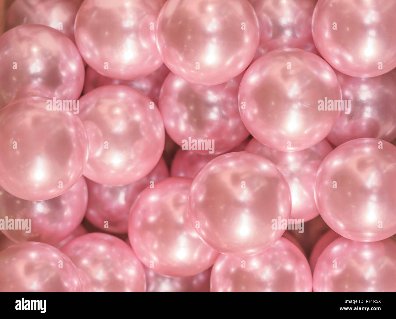 Gros plan texture découpe sur plusieurs perles brillantes rose. Banque D'Images