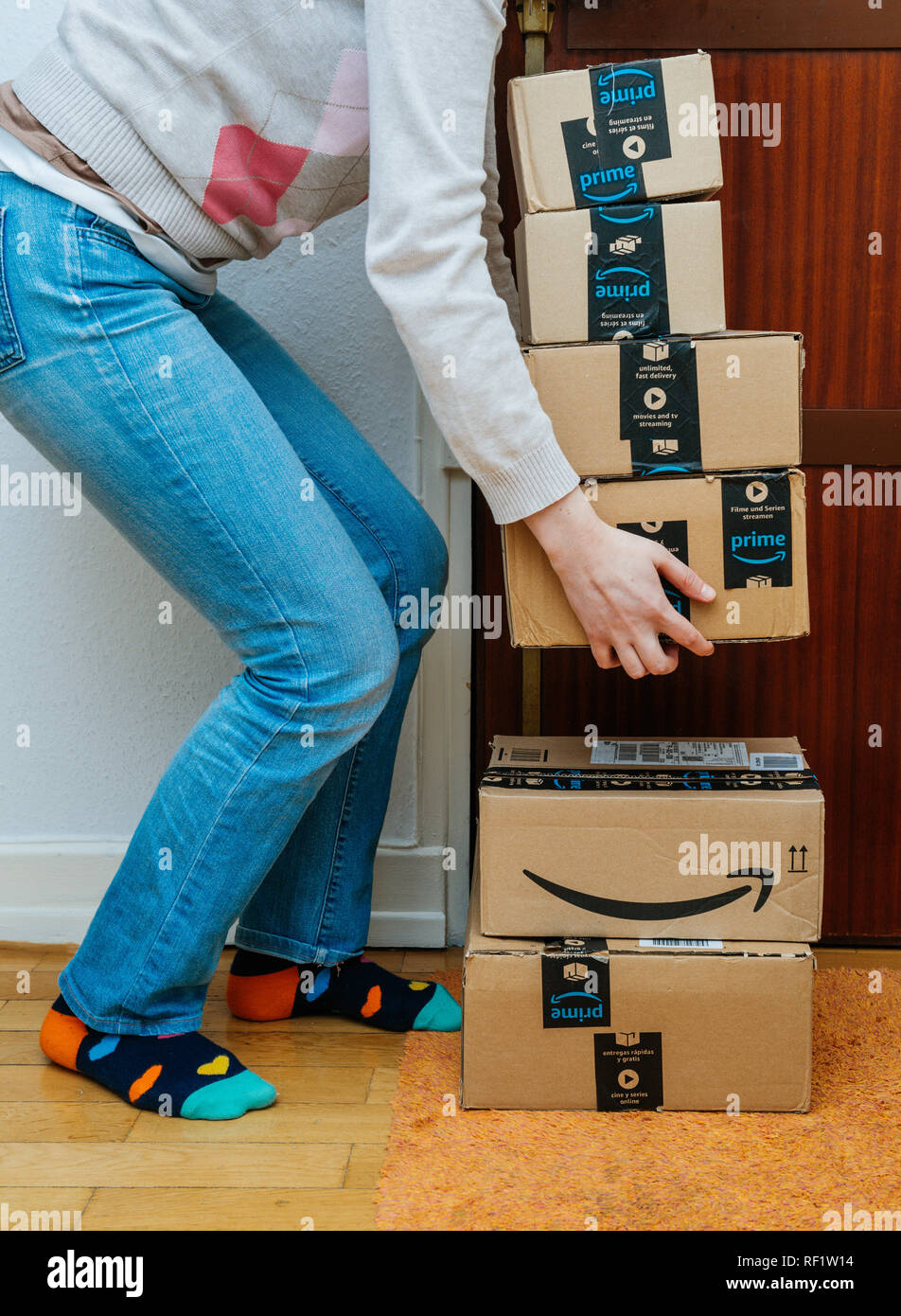 PARIS, FRANCE - 13 jan 2018 : Pile de Amazon premier colis livrés à une  porte d'accueil femme essayant de soulever les gros cartons pour les  transporter à house Photo Stock - Alamy
