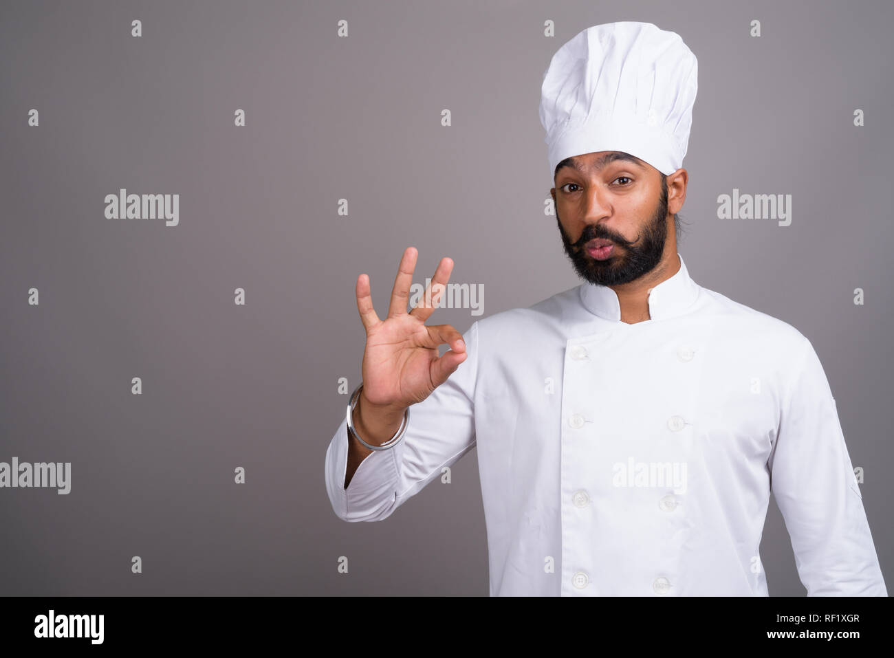 Beau jeune homme indien chef making OK sign Banque D'Images