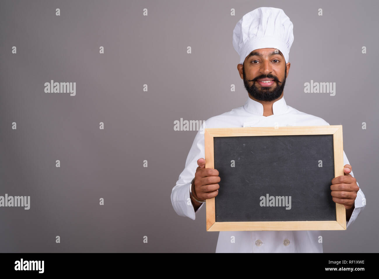 L'homme indien chef holding empty black board with copy space Banque D'Images