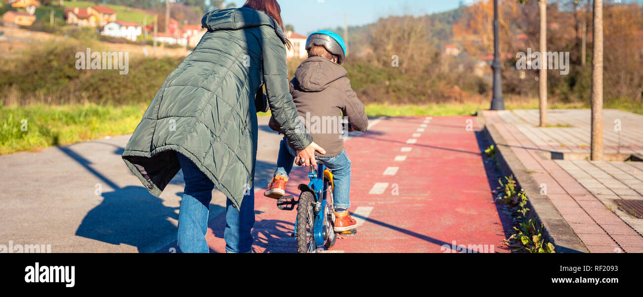 L'enseignement de mère fils à faire du vélo dans la piste cyclable Banque D'Images