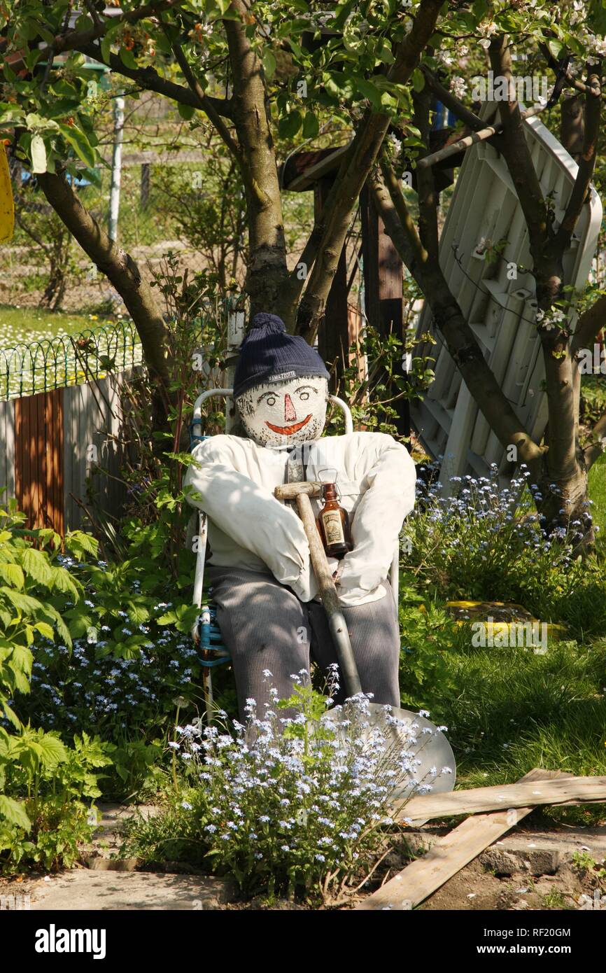 Jardin avec une figure assise sur une chaise en train de boire une bière, Dortmund-Wickede, Dortmund, Rhénanie du Nord-Westphalie Banque D'Images