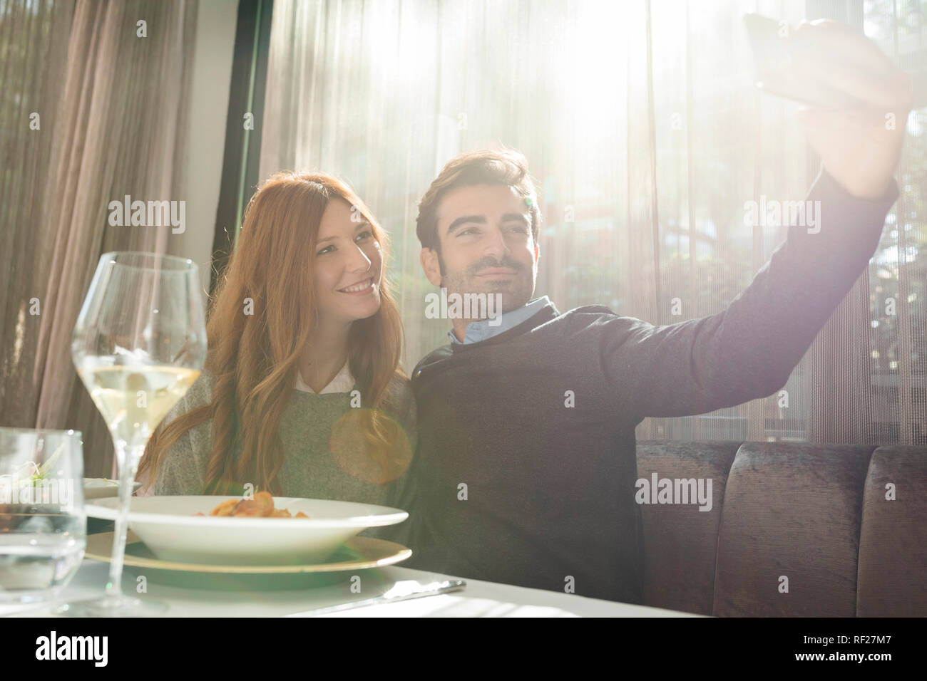 Smiling couple prendre un dans un restaurant selfies Banque D'Images