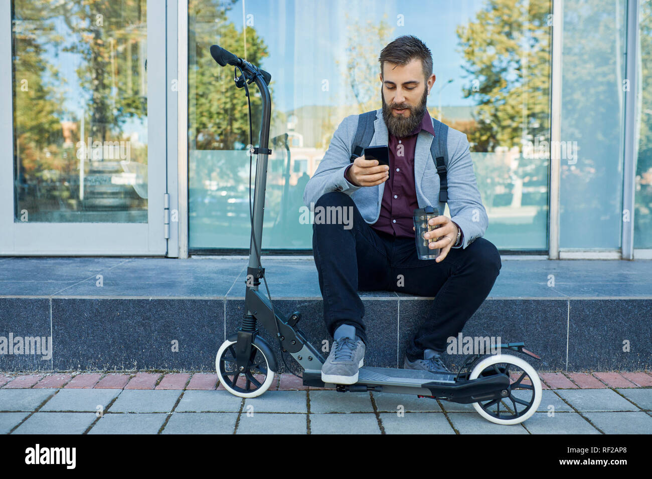 A l'extérieur par téléphone cellulaire à côté de scooter Banque D'Images