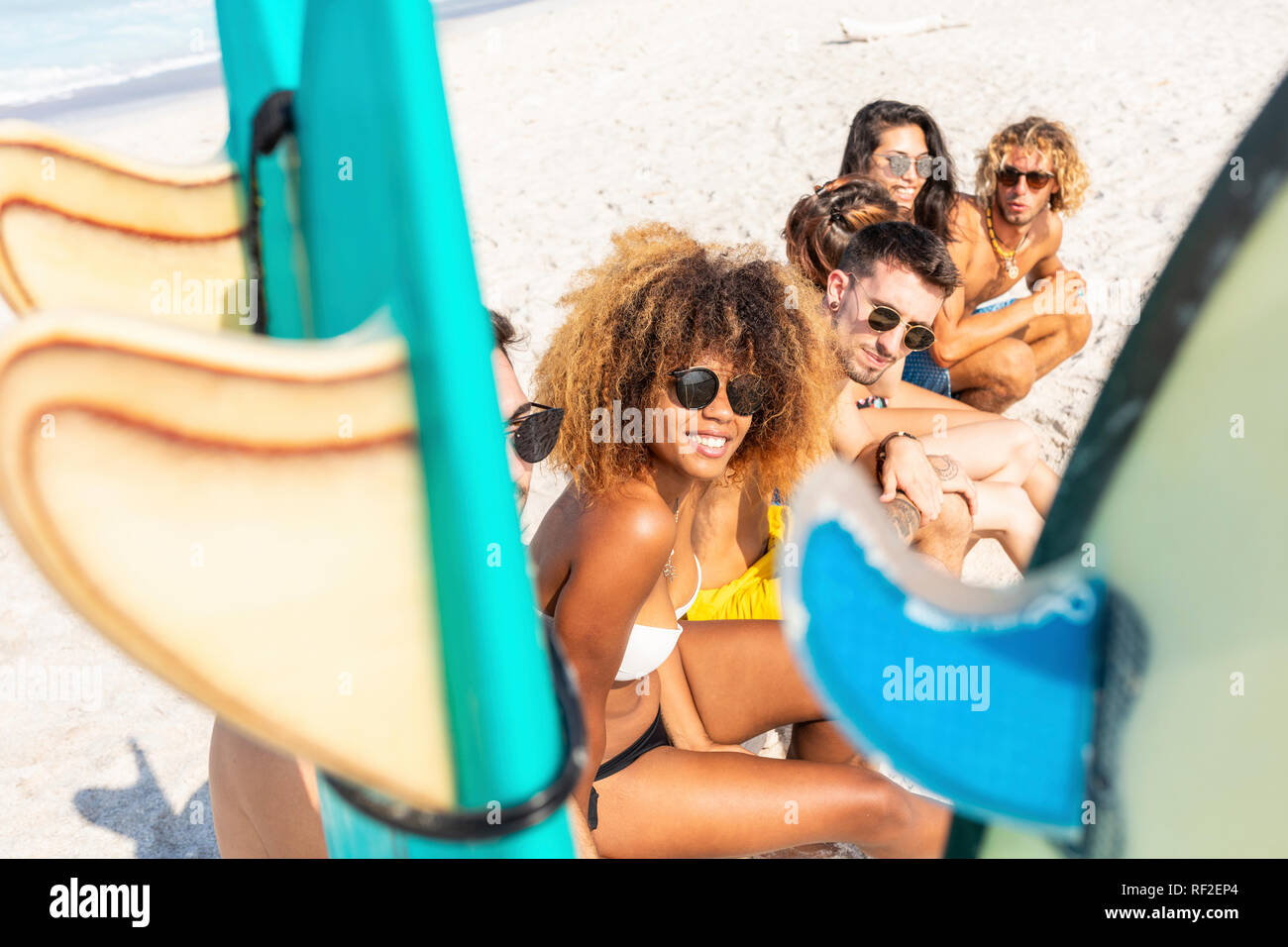 Les jeunes surfeurs de prendre une pause, assis sur la plage Banque D'Images