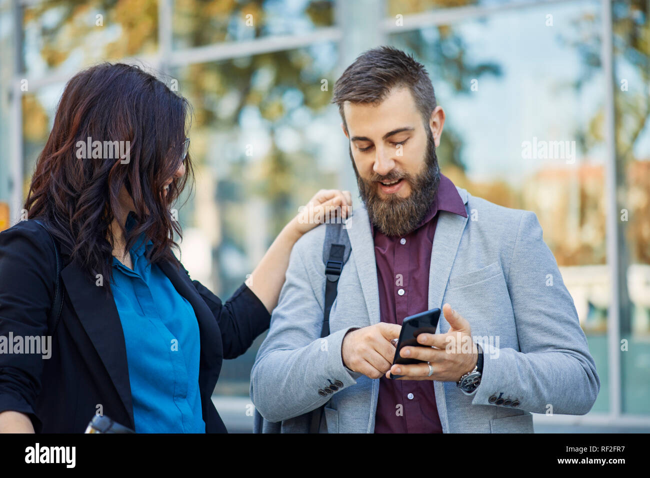 Businessman and businesswoman with cell phone outdoors Banque D'Images