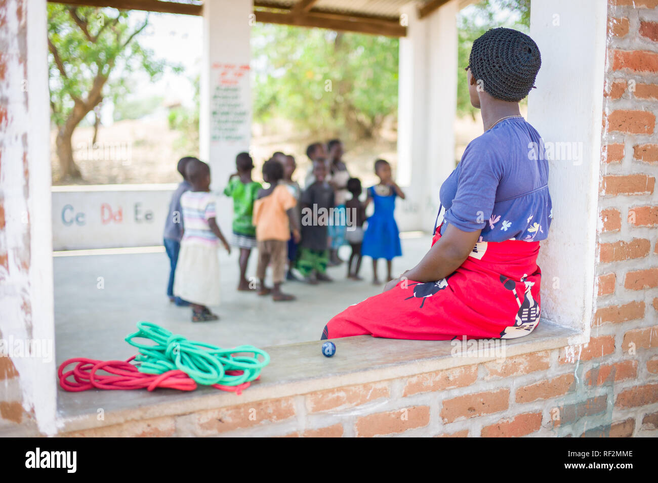 Un enseignant veille sur sa classe de jeunes enfants dans un milieu rural, École ouverte prix près de Chikwawa, Malawi. Banque D'Images