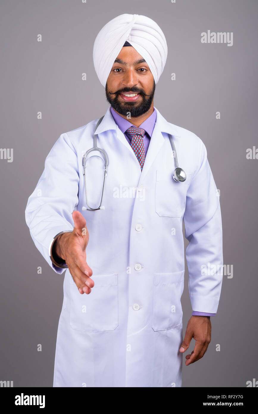 Homme Sikh indien médecin sourire et poignée de donner Banque D'Images
