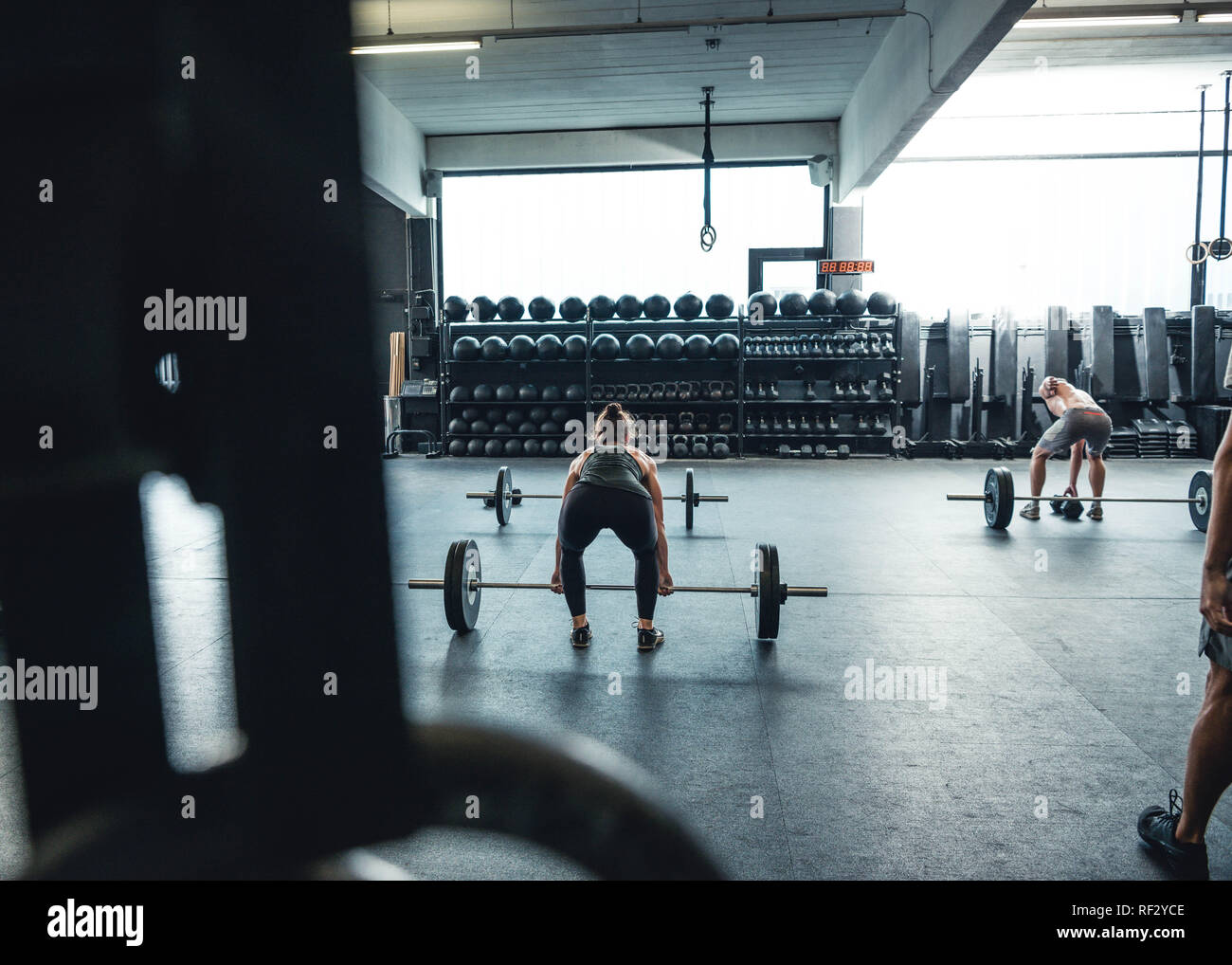 Des hommes et des femmes authentiques la levée de poids et de vous entraîner dans une salle de sport à l'établissement. Banque D'Images