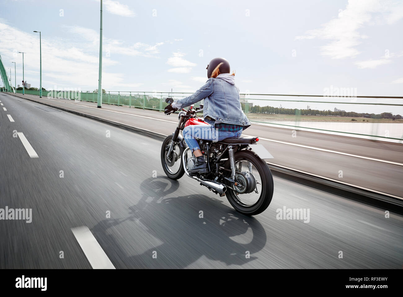 Young woman riding on bridge Banque D'Images