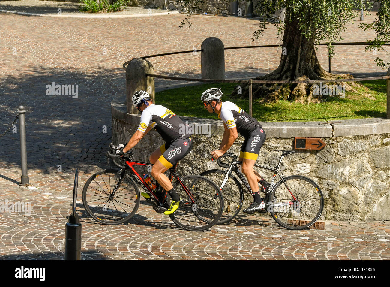 GARDONE RIVIERA, ITALIE - Septembre 2018 : Deux cyclistes pédaler jusqu'à l'extérieur de la colline escarpée le Vittoriale degli Italiani gardens à Gardone Riviera. Banque D'Images