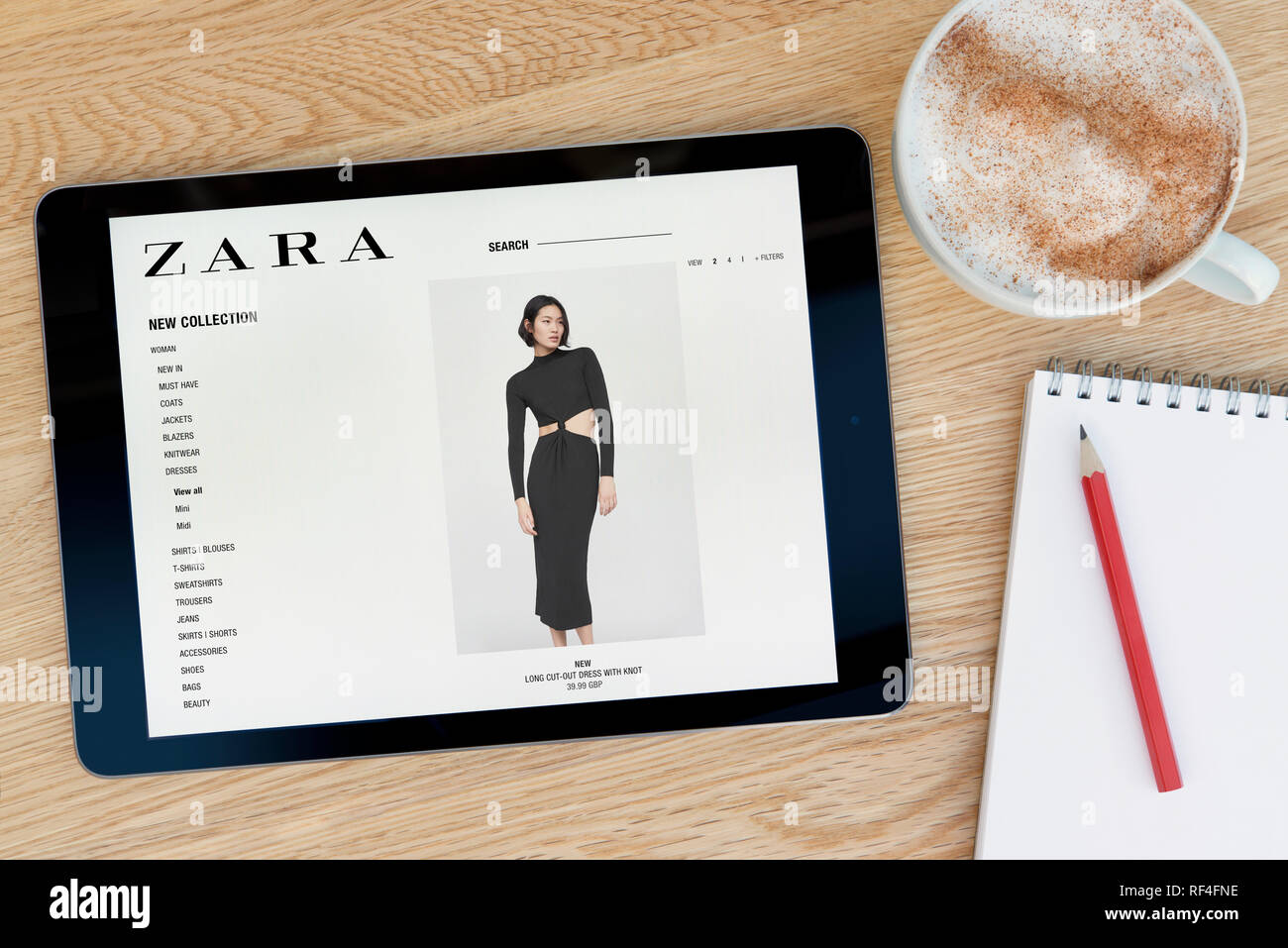 Le site web dispose d'un Zara iPad tablet device qui repose sur une table  en bois à côté d'un bloc-notes et un crayon et une tasse de café (rédaction  uniquement Photo Stock -